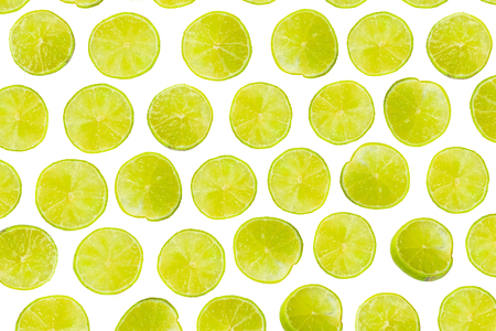 Isolated lime pattern or wallpaper on white background. Summer concept of fresh ripe lime liths and slices shot from aboveの写真素材