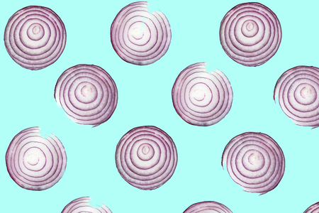 Top view pattern of fresh bright red onion rings on turquoise blue background. Shot from above of multiple sliced onionsの写真素材