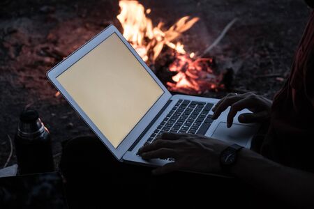 Working with technology in unconventional place concept. Working remotely with computer next to a...
