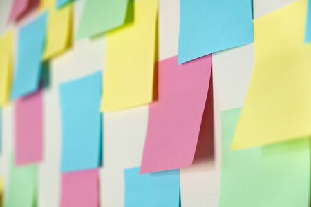 Sticky paper notes on a planning board, close-up view. Planning, brainstorm, diversity or fresh ideas concept - pattern of empty multicolored paper notesの写真素材