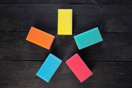 Sponges form a pentagon star shape, top view. Five pieces of dishcloth on dark background, shot from...