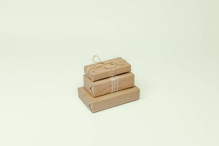 Presents in wrapped in recycled paper, copy space. Holiday gifts wrapped in sustainable natural package in isolated backgroundの写真素材