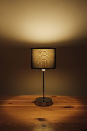Electric lamp on the table top, natural low key light. Cozy bedroom light at night, minimalistic and...