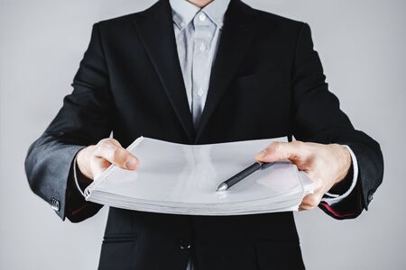 Person giving out book of papers or a large case for signature or deal completion. Making a deal,...