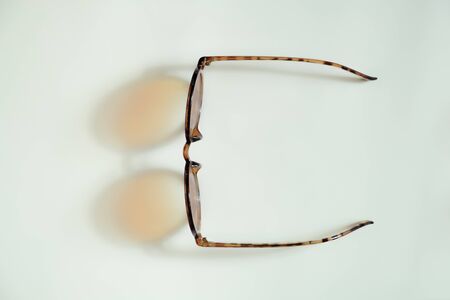 Sunglasses dropping shadows on white background. Concept of vacation, summer rest or holidaysの写真素材