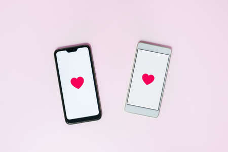 Two phones with heart symbols, concept of love texting, dating apps