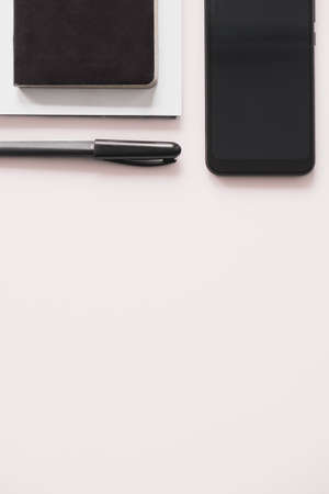 Business flat lay on white background with copy space. Smartphone, writing pen and notebook organizer on minimalistic backgroundの写真素材