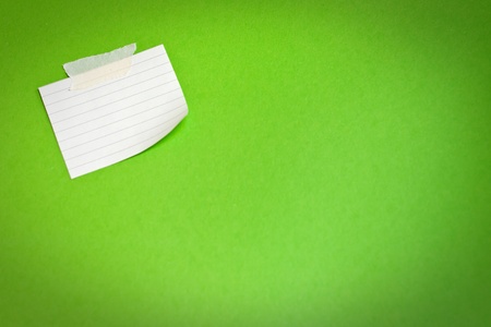 White note paper attached on green background の写真素材