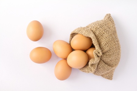 Brown eggs in canvas sack isolated on a white background の写真素材