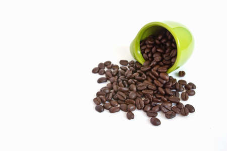 Coffee beans in green cup on white backgroundの写真素材