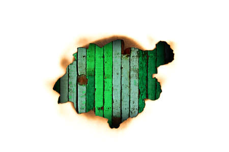 Burnt hole in a paper over green wooden の写真素材