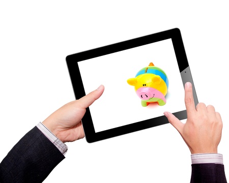 Businessman hands are holding the contemporary digital tablet with piggy bank style money box  Concept image on cloud-computing theme  Isolated on white の写真素材