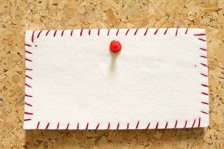 reminder note with orange pin on corkboard