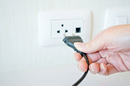 Electric cable with hand and Electrical Outlet on the Wall  