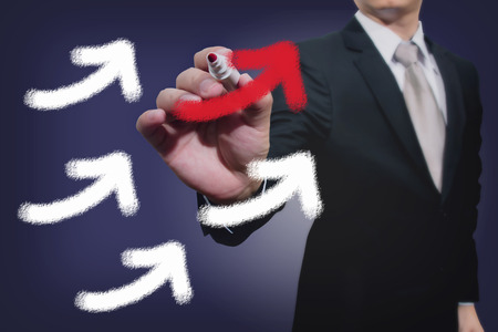 Businessman drawing rising arrowsの写真素材