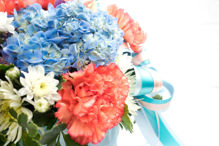 Bouquet with different kind of flowers in basket isolated on whiteの写真素材