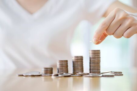 woman put coins to stack of coins
