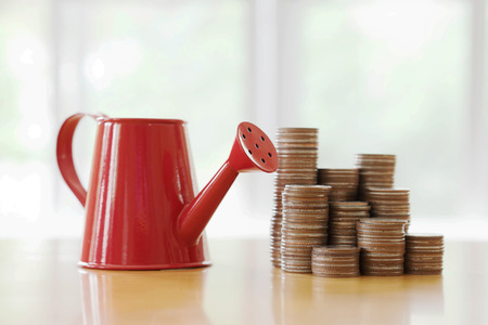 Red watering can with coin (path in side) isolateの写真素材