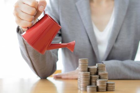 hand business woman and red watering can with moneyの写真素材