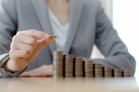 Close-up Of A Businesswoman Making Stack Of Coinsの写真素材