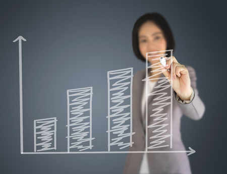 Business woman writing on graphの写真素材