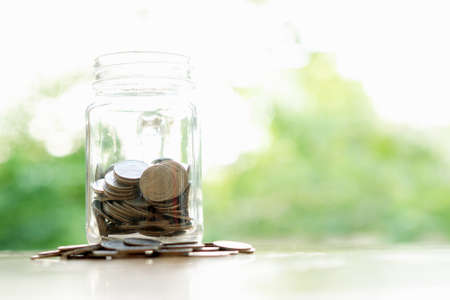 Savings word with money coin in glass jar.financial concept の写真素材