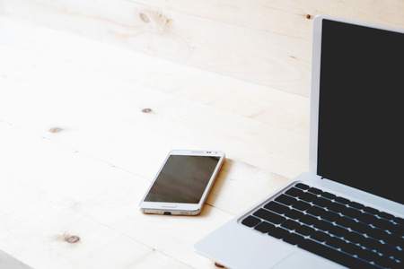 laptop and smart phone on a wooden table.の写真素材