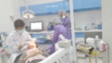 Dentist and assistant examining patient in clinic - Blurの写真素材