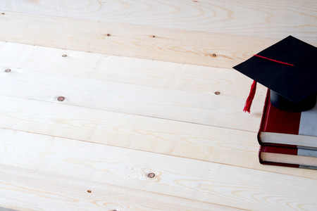 Graduation cap with graduation paper on a stack of book の写真素材