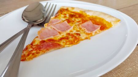 Pieces of fresh pepperoni pizza on a plateの写真素材