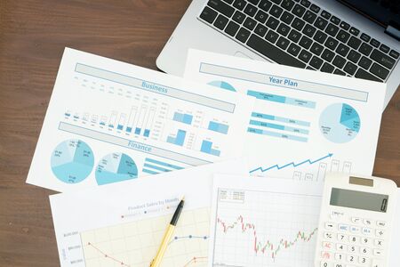 Business report and laptop on desk