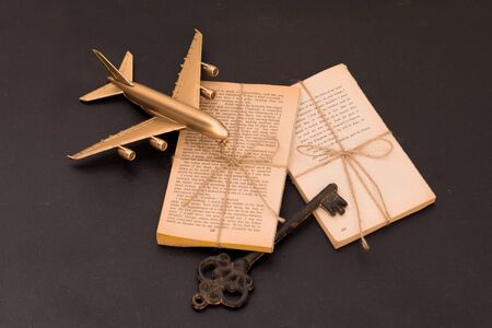 book. keys and model airplane on table