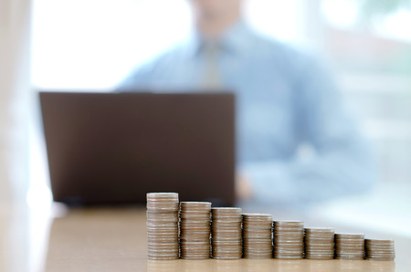 businessman typing on computer keyboard working . coins stackの写真素材
