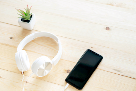 Smartphone and headphones on the table woodの写真素材