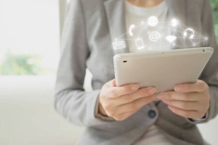 Businesswoman hand holding smart phone with digital technology global networkの写真素材