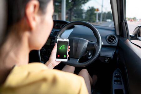 Close-up of woman talking on mobile phone while driving a car.