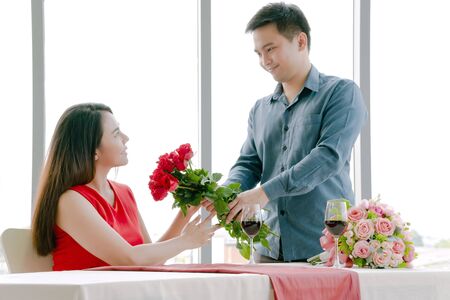 Man giving red rose bouquet with womanの写真素材