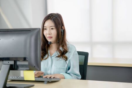 Cute businesswoman talking with clients in front of her computer