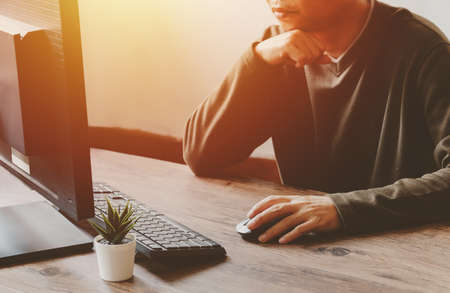 Man working with desktop computer in office closeup of hand clicking mouse, business conceptの写真素材
