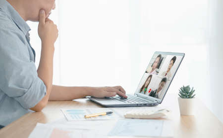 businessman talking about sale report in video conference. Asian team using laptop and tablet online...