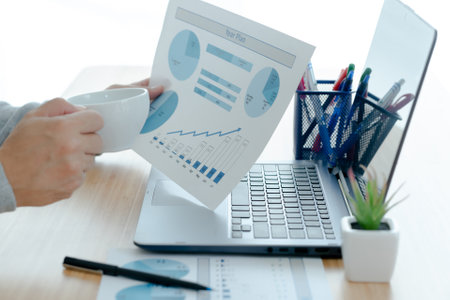 Businessman analyzing graph document and holding coffee. business concept