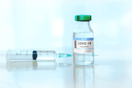 Coronavirus COVID-19 Vaccine Vials and Syringe On Reflective Surface.Vaccine Concept