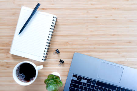 flat lay composition with notebook, pen, coffee, plant, laptop on wood background. Conceptの写真素材