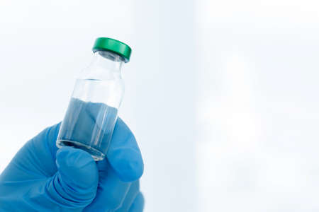 Close up vaccines fight against virus, doctor or scientist in laboratory holding a syringe with...
