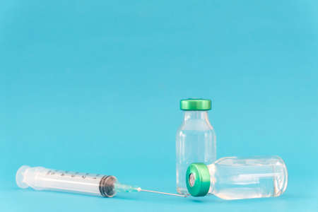 Potential trials stage concept on blue background. Close up Vials with sterile needle syringe. Research and Development, Vaccination concept.の写真素材