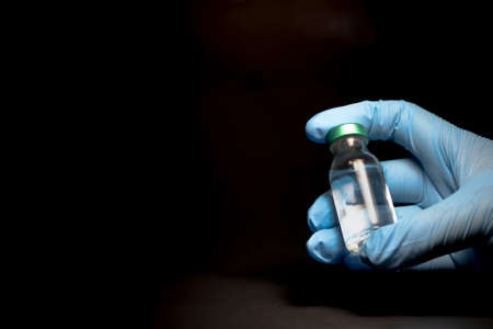 Potential trials stage concept on black background. Close up Vials with sterile needle syringe. Research and Development, Vaccination concept.の写真素材