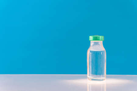 Potential trials stage concept on blue background. Close up Vials with sterile needle syringe. Research and Development, Vaccination concept.の写真素材