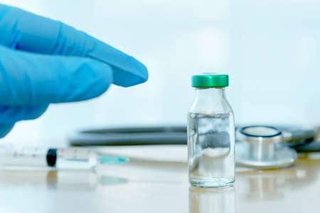 Close up vaccines fight against virus, doctor or scientist in laboratory holding a syringe with...