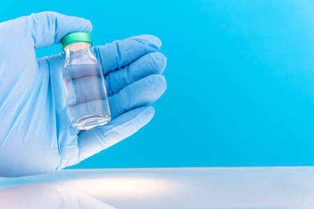 Potential trials stage concept on blue background. Close up Vials with sterile needle syringe. Research and Development, Vaccination concept.の写真素材