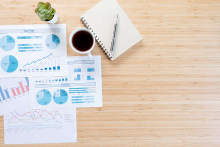 Work from home. desk office paperwork, coffee cup and pen on wood table. Flat lay top view copy space.の写真素材